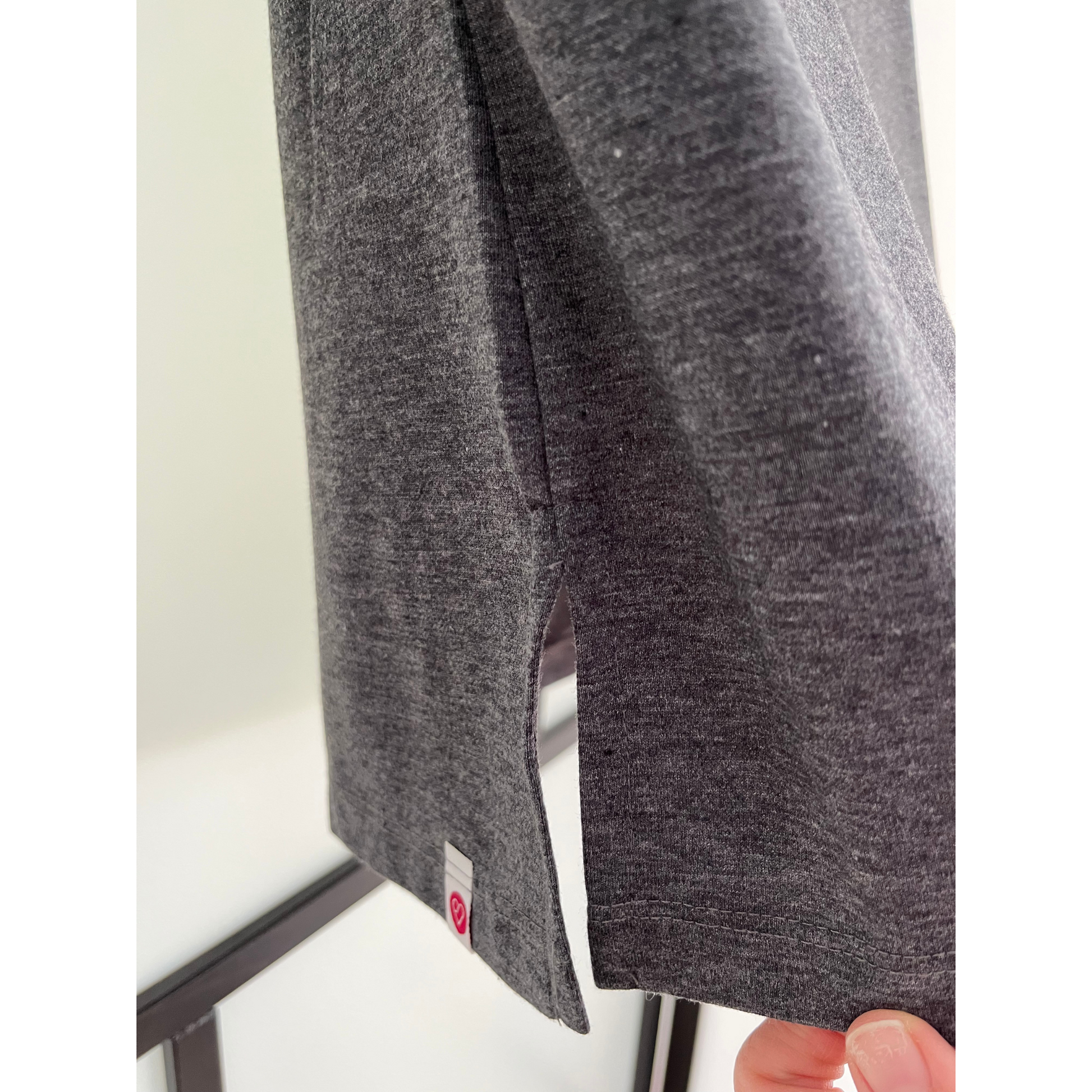 Close-up of side slit on gray breastfeeding nursing top with soft fabric and postpartum comfort.