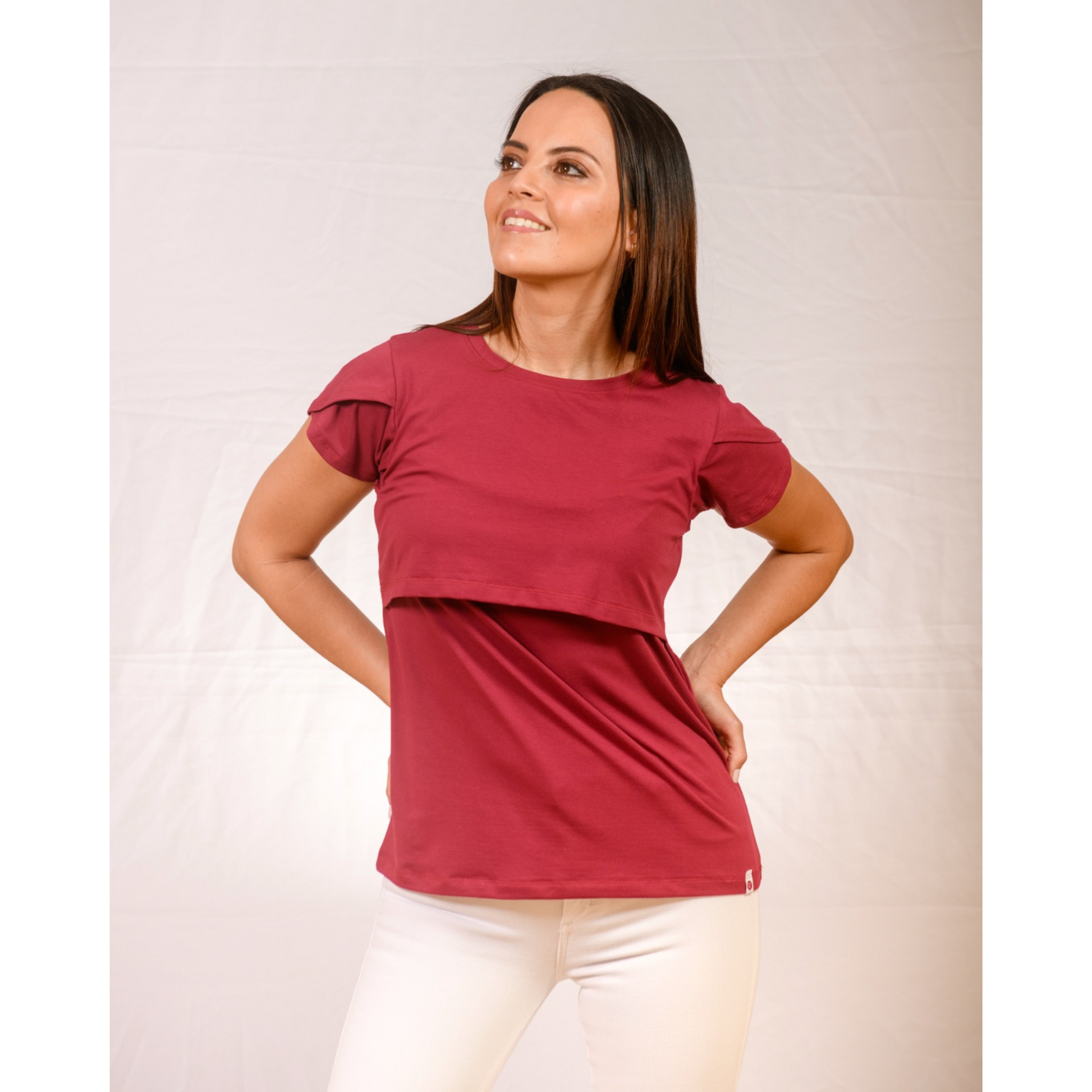 Woman wearing cherry nursing top with front-layered design, short sleeves, and soft fabric for postpartum comfort.