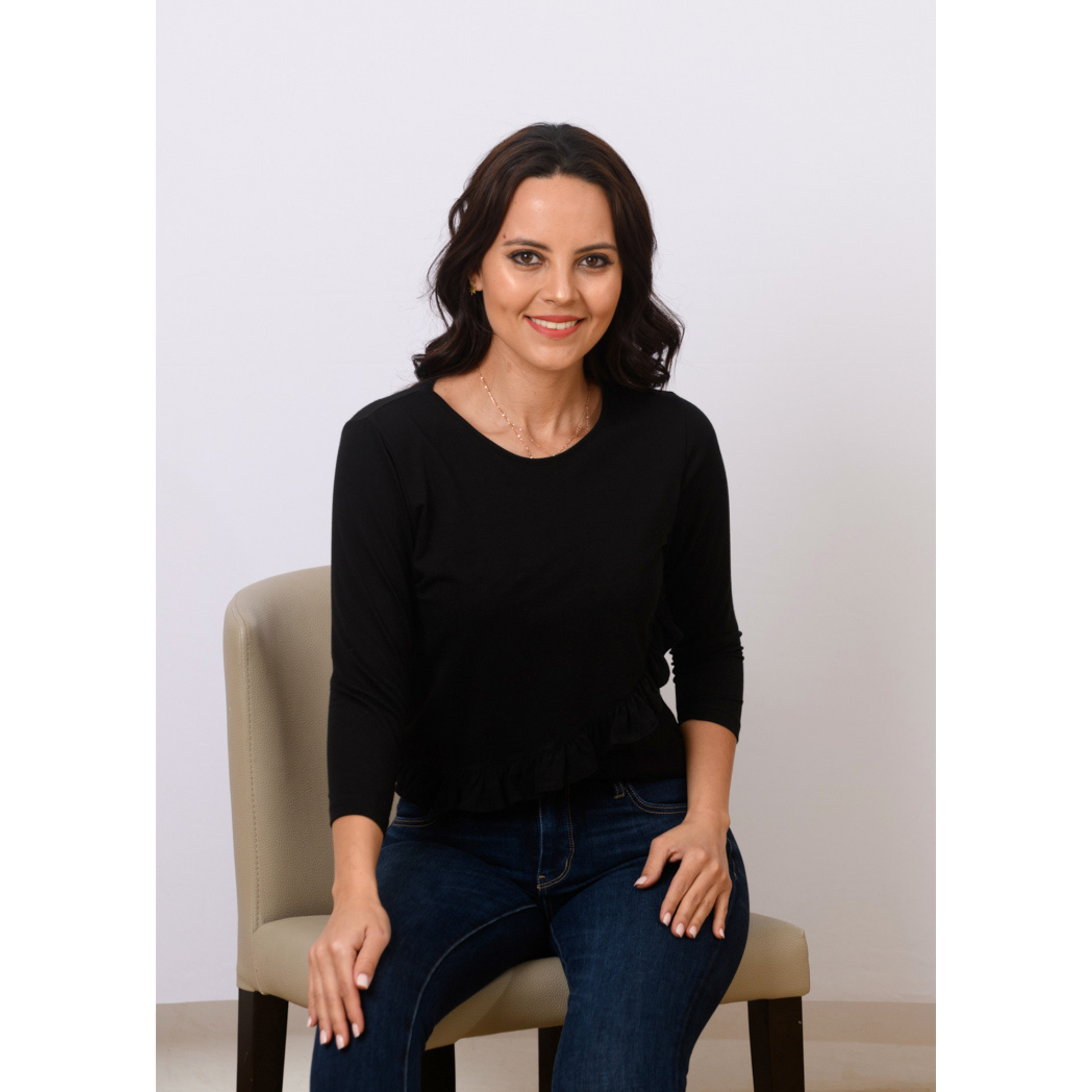 Woman wearing black breastfeeding nursing top with front-layered nursing access and ruffle detail for stylish postpartum wear.